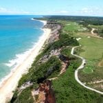 Vista aérea com detalhes na faixa de pura natureza frente mar com campo de golf