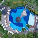 Aérea da piscina do resort com suas cores variadas em meio a natureza