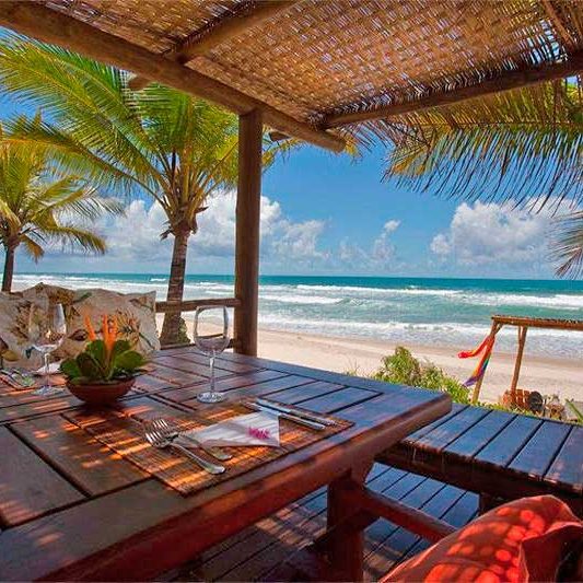 Gastronomia com vista para praia trazendo sombra