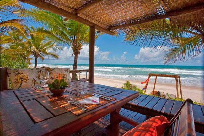 Gastronomia com vista para praia trazendo sombra