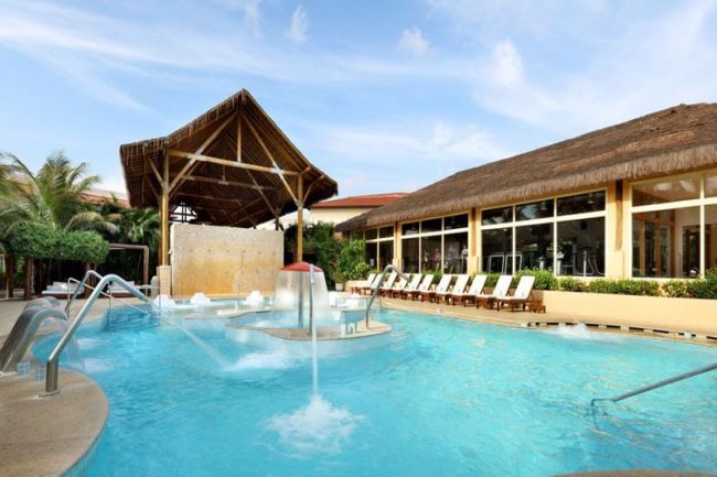 Piscina do spa com duchas relaxantes e espreguiçadeiras postas na beira