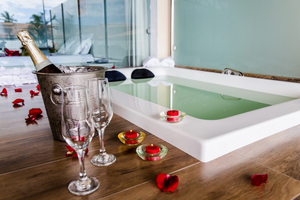 Espumantes junto a banheira e detalhes do amenities