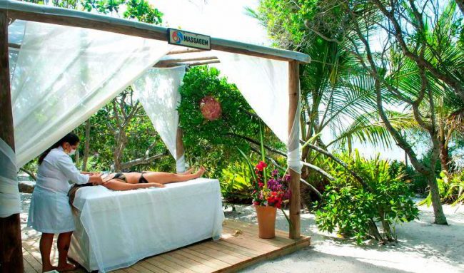Massagem sendo aplicado em meio a natureza com espaço preparado com cama para aplicação