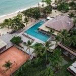 Vista aérea da piscina com hotel frente mar