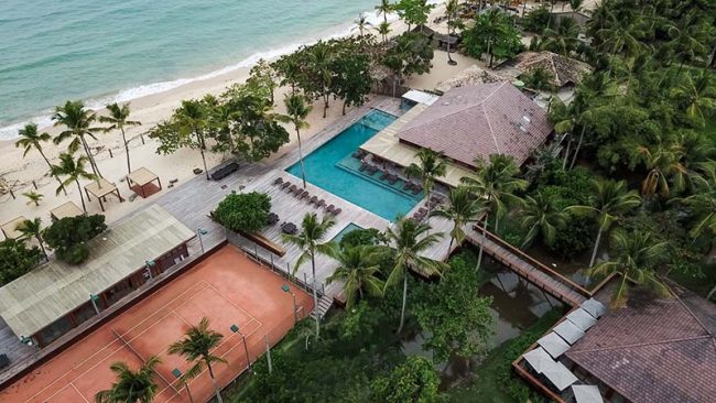 Vista aérea da piscina com hotel frente mar